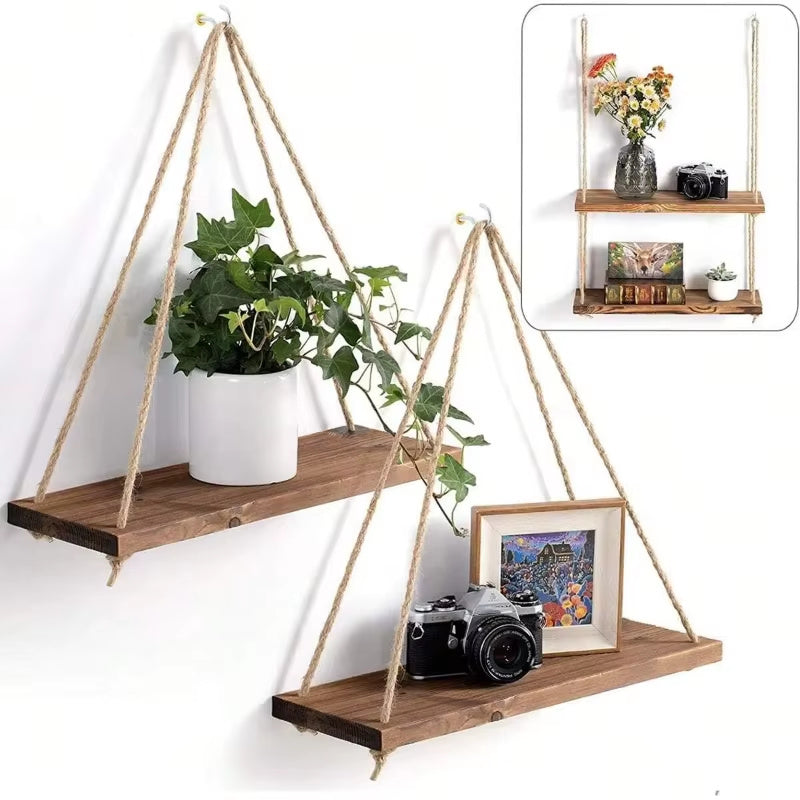 Set of wooden rope hanging shelves with hemp ropes mounted on wall displaying potted plant, camera, and decor items for rustic home storage