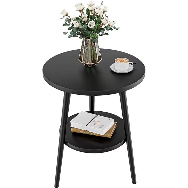 Black side table with a vase of flowers, coffee cup, and books on a white background
