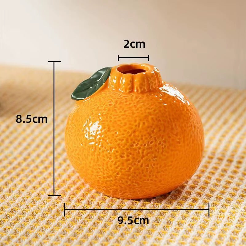 Small orange-shaped ceramic vase with dimensions labelled, showing height, width, and opening size.