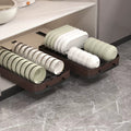 Pull-out cabinet dish drying rack with trays holding plates, bowls, and cups neatly organized inside a kitchen cabinet.