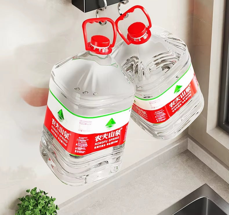 Wall-mounted heavy-duty hooks holding large water jugs securely for space-saving kitchen storage.